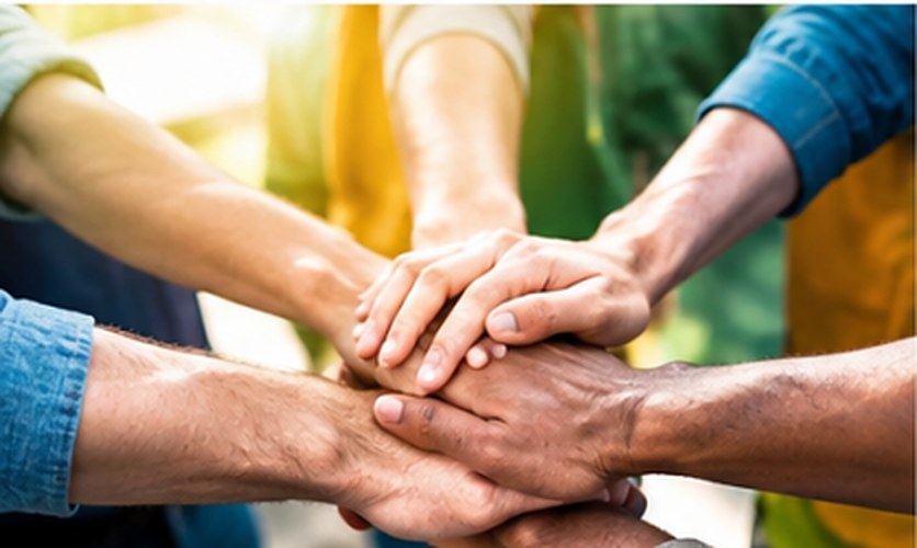 A group of people stacking their hands together in a sign of teamwork